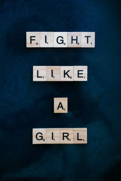 Empowering message displayed with Scrabble tiles on a dark background.