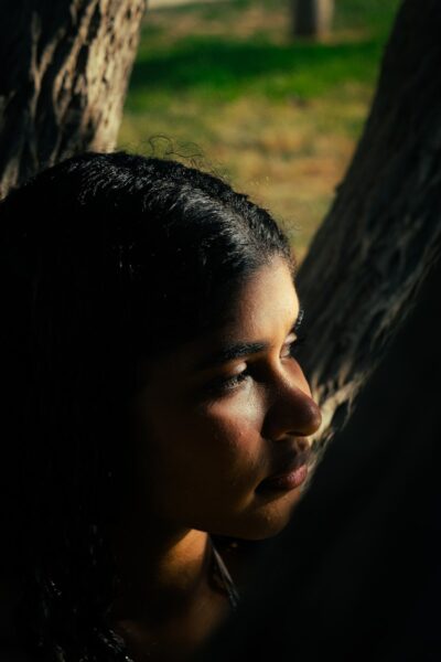 Young woman's profile in dappled sunlight.